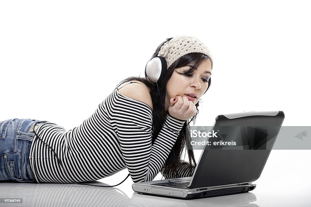 Listen Music with a Laptop Young woman working with a laptop and listen music at the same time 20-24 Years Stock Photo