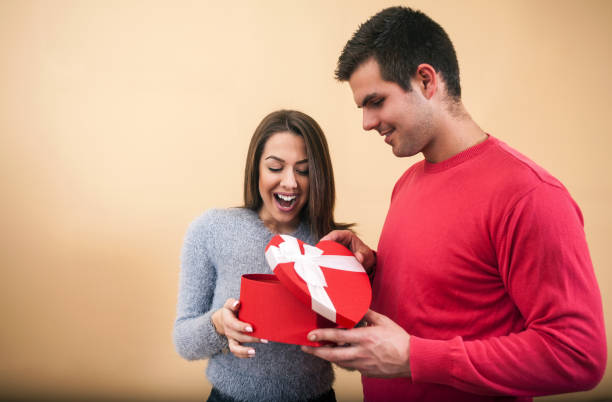 istock Girl smiling and opening present in a hart shaped box 917693892
