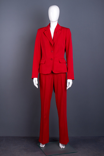 Mannequin in female red elegant suit. Full length female mannequin in red blazer and trousers. Feminine elegance and style.