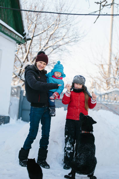 istock family plays with labrador in the snow 917695750