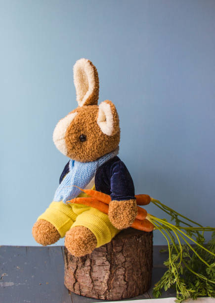 istock Sweet bunny with three orange carrots. 917704752