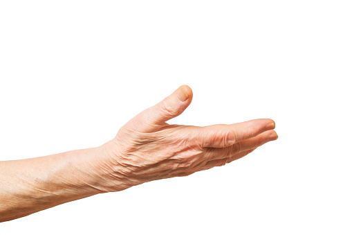 Elderly woman, wrinkled hand palm w/ clearly visible veins reaching out forward. Old lady arms, freckles. Isolated white background, close up, overhead, copy space.