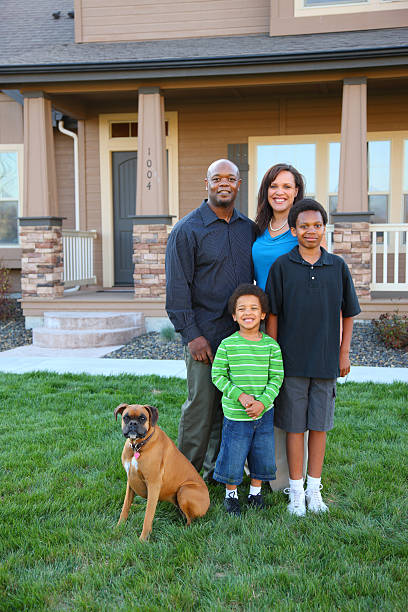 Lovely family of four with dog outside their dream home Family and dog in front of home front stoop photos stock pictures, royalty-free photos & images