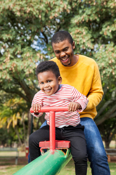 istock Father and son play on a seesaw at the park. 917710008