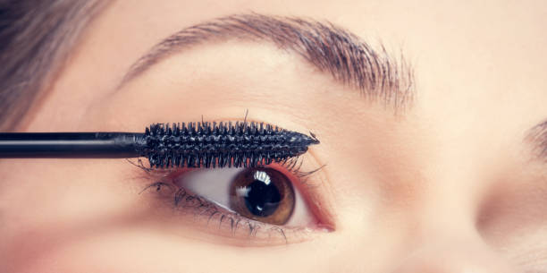 istock Young woman applying mascara to her lashes. 917711610