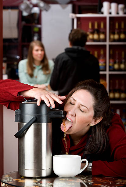 Woman drinking coffee directly from a dispenser  coffee addict stock pictures, royalty-free photos & images