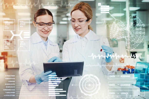 istock Smiling women holding a tablet while working in the laboratory 917715158