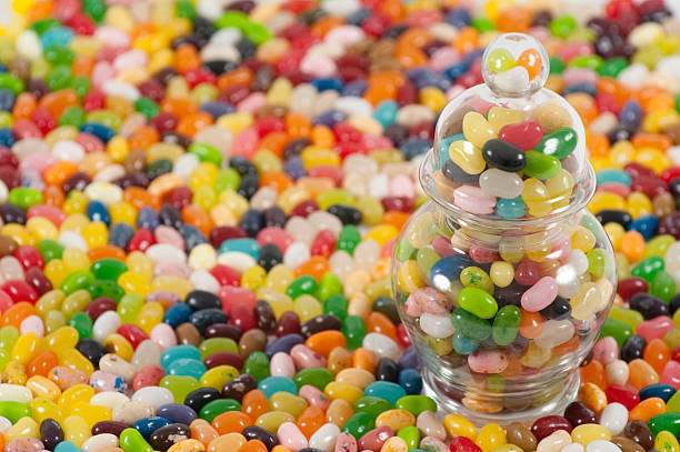 Jellybeans with jar on the side  jellybean stock pictures, royalty-free photos & images