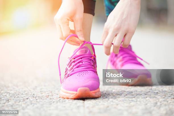 Young Woman Runner Tying Shoelaces Stock Photo - Download Image Now - Power Walking, Exercising, Walking
