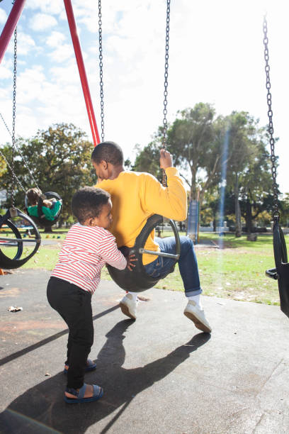 istock Son pushes his father on a tyre swing at the park. 917729520