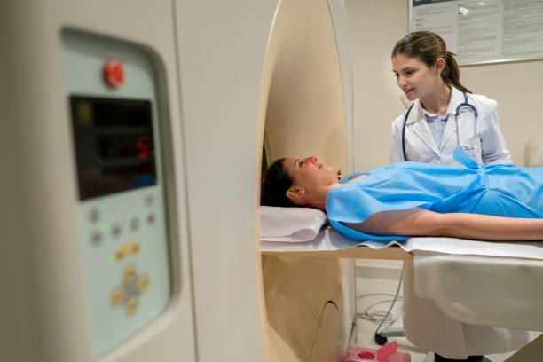 istock Female doctor explaining to her patient about the CT scan while she is already lying down with a hospital gown ready 917730160