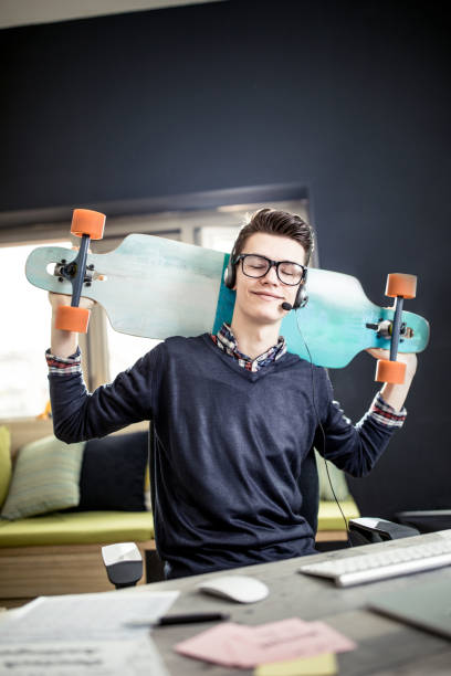 istock Young man with longboard in the study room 917730258