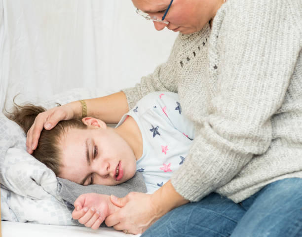 A child with epilepsy during a seizure A child being cared for during an epileptic seizure by a qualified special needs carer epilepsy stock pictures, royalty-free photos & images