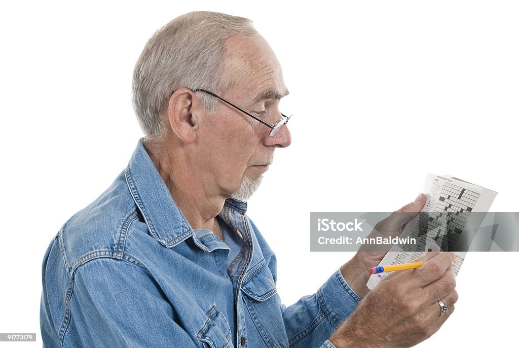 Старший человек делает crossword - Стоковые фото Кроссворд роялти-фри