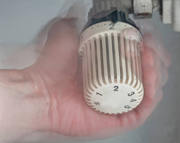 istock Hand adjusts the temperature on a heating thermostat 917734560