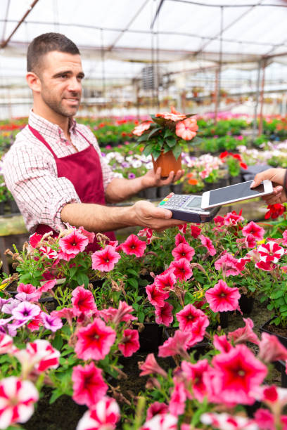 istock Greenhouse worker selling pottered flowers 917734916