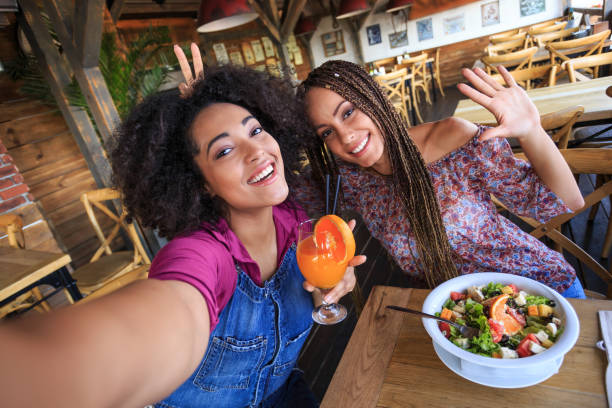 istock Young women in restaurant taking selfie 917734958