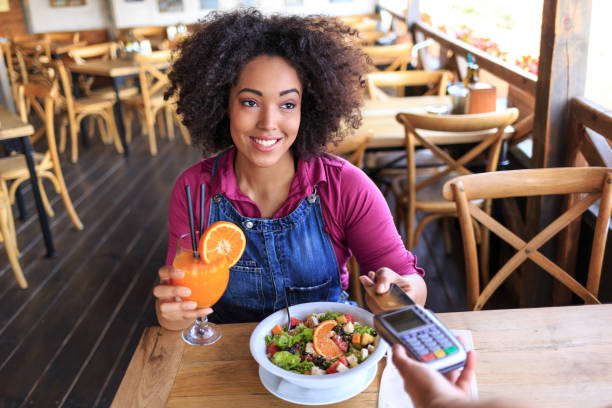 istock Woman using credit card for contactless payment in restaurant 917734968