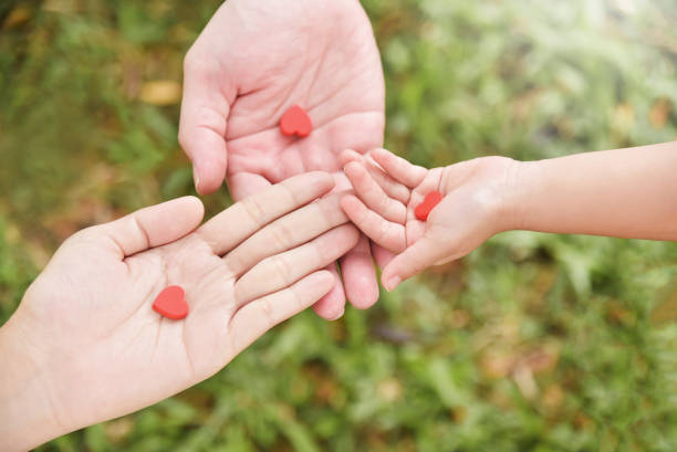 istock Family hands holding red hearts together. 917735340