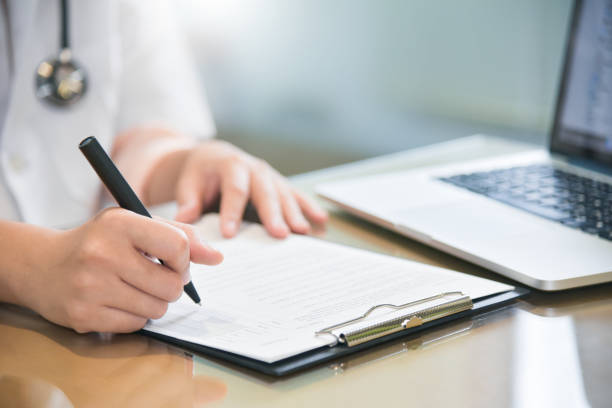 istock female doctor is using laptop and writing something on clipboard. 917735400