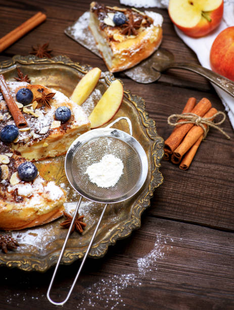 istock baked round apple pie and iron sieve with powdered sugar 917739652