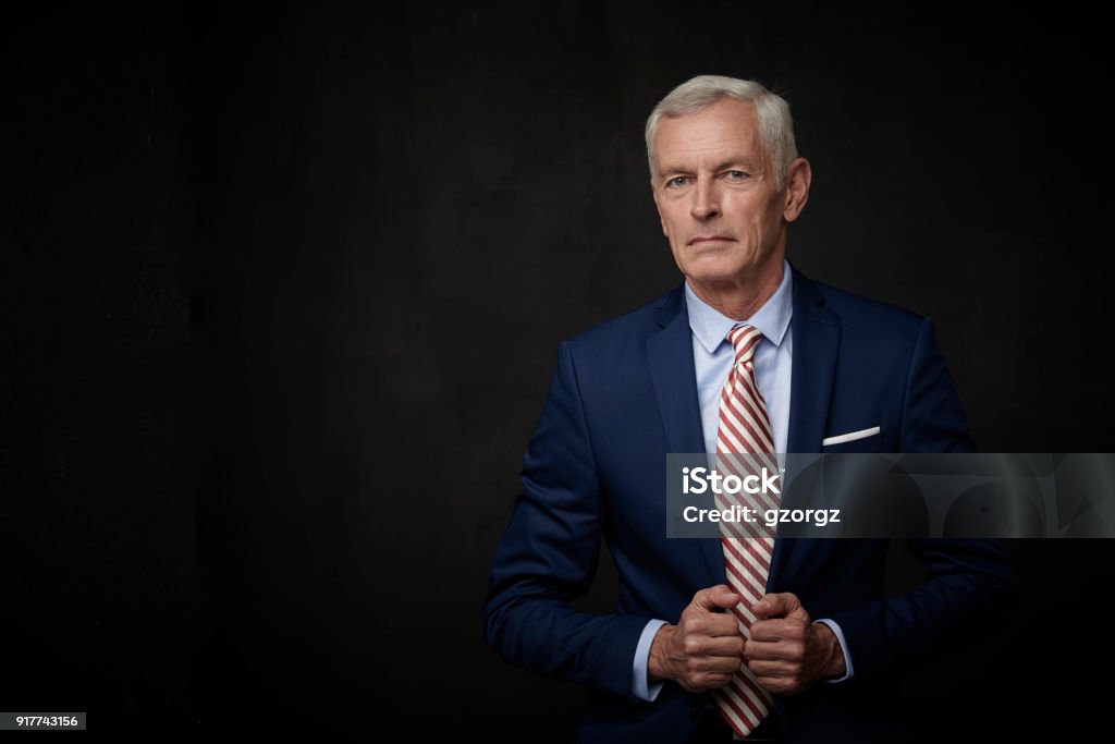 Senior businessman portrait Executive senior lawyer businessman wearing suit and looking at camera while standing at isolated black background with copy space. Lawyer Stock Photo