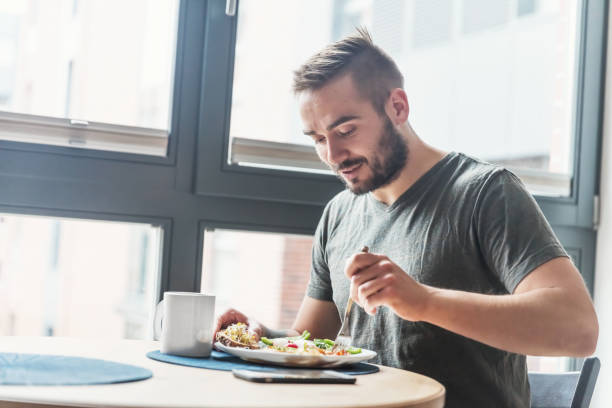 homem comendo um saudável pequeno-almoço. - buffet breakfast food table - fotografias e filmes do acervo