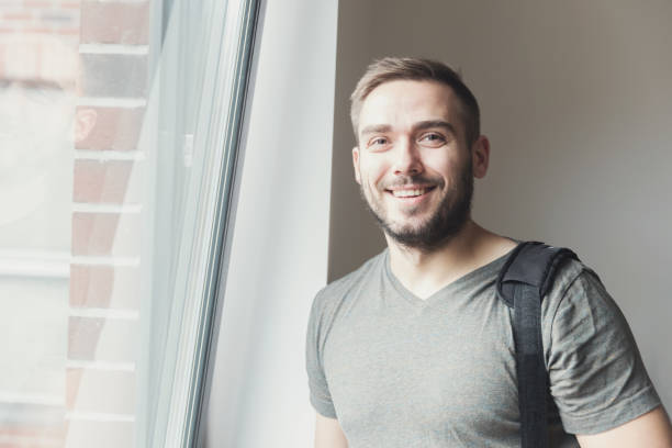 istock Young man smiling next to the window. 917743354