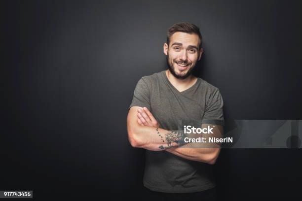 Joyful Handsome Man On A Black Background Stock Photo - Download Image Now - Men, Tattoo, Black Background