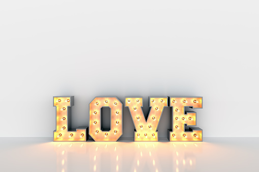Love word with light bulbs inside on white clean wall background. Valentine's Day greeting card.