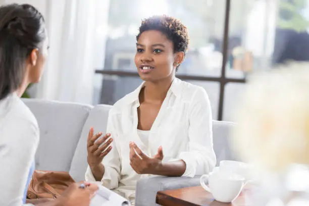 Photo of Young woman discusses issues with female therapist