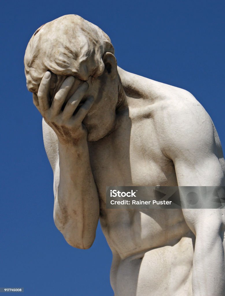 Facepalm statue holding head in hand A statue holding its head in its hand in despair Statue Stock Photo