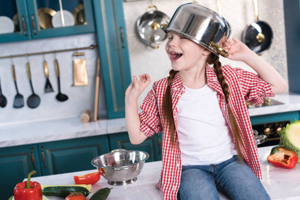 istock happy little child with pan on head sitting on kitchen table 917745060