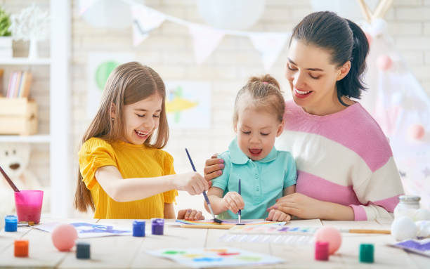 istock Mother and daughters painting together 917745204