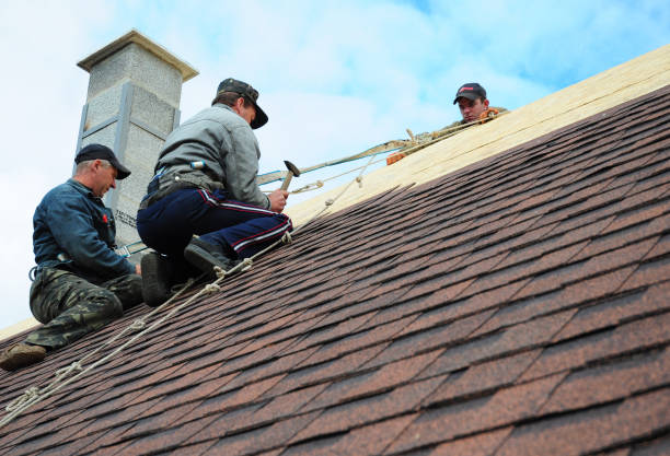 Two construction workers are standing on the rooftop of a high-rise residential building. They are taking a break between stages of the exterior wall insulation work.