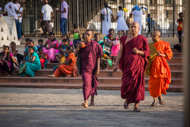 Kandy, Sri Lanka - December 11, 2016: Buddhist monks are visiting Sri Dalada Maligawa (Temple of the Sacred Tooth Relic of Lord Buddha). They participate in the ceremony of giving gifts to Buddha. The Temple can get crowded as it receives many tourists, pilgrims, and Buddhists monks. Kandy was the last capital of the Sinhalese kings and is a UNESCO world heritage site.