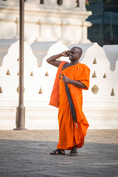 Kandy, Sri Lanka - December 11, 2016: Buddhist monks are visiting Sri Dalada Maligawa (Temple of the Sacred Tooth Relic of Lord Buddha). They participate in the ceremony of giving gifts to Buddha. The Temple can get crowded as it receives many tourists, pilgrims, and Buddhists monks. Kandy was the last capital of the Sinhalese kings and is a UNESCO world heritage site.