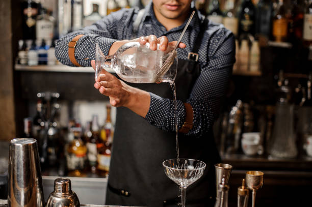 istock Barman pouring cold alcoholic drink into a cocktail glass 917753856