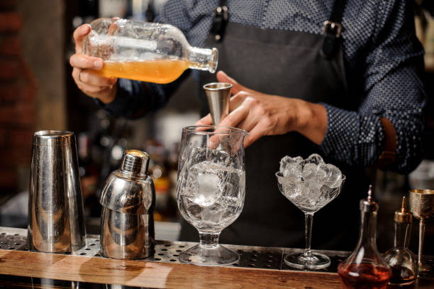 istock Barman pouring syrup into the large cocktail glass 917754012