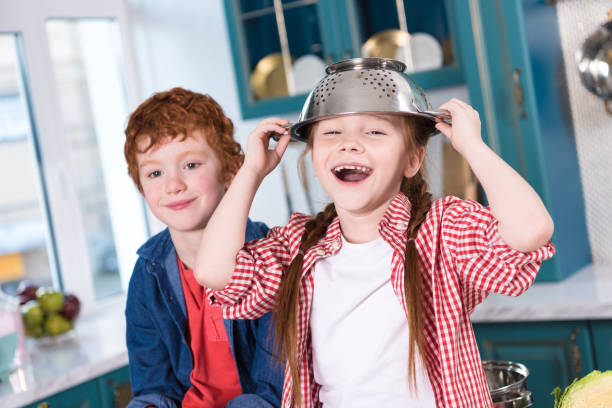 istock adorable happy little kids having fun and smiling at camera in kitchen 917754262