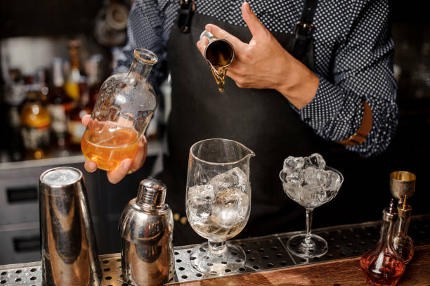 istock Barman adding a portion of syrup into the large cocktail glass 917754458