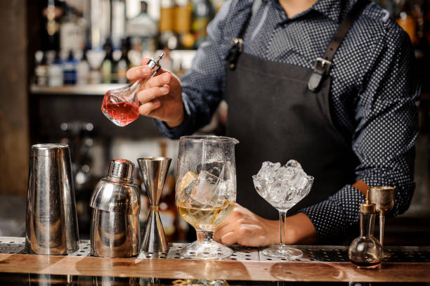 istock Barman pouring fruit syrup into the large cocktail glass 917754648