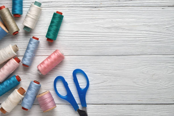 istock Sewing accessories, threads, scissors. Accessories for needlework on a white wooden background. Top view. 917755468