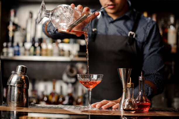 istock Bartender pouring red alcoholic drink into the cocktail glass 917757994