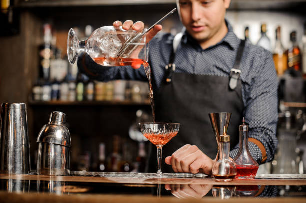 istock Barman adding red alcoholic drink into the cocktail glass 917758204