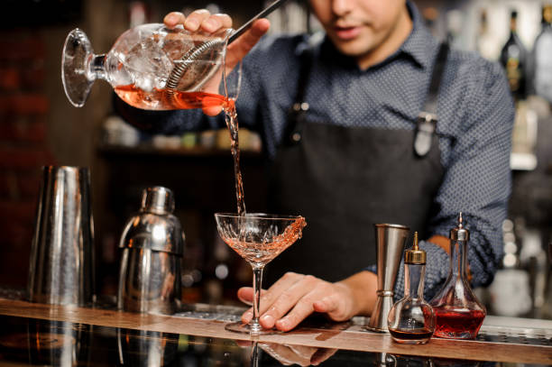 istock Bartender adding red alcoholic drink into the cocktail glass 917758648