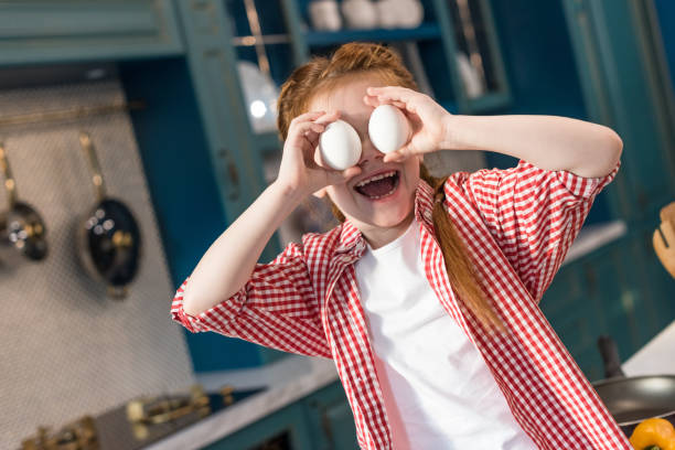 istock adorable little child holding eggs and smiling at kitchen 917759786
