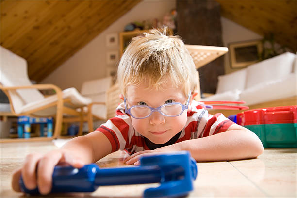 istock Blonde kid lying down on floor playing with toys 91776242