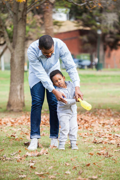 père enseignant son magnifique fils comment se balancer une batte de base-ball. - men baseball baseball cap baseball bat photos et images de collection