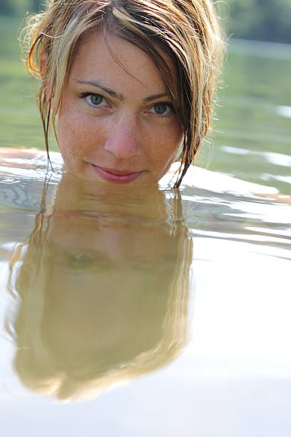 Happy, little girl is swimming in the ocean in a rainy day